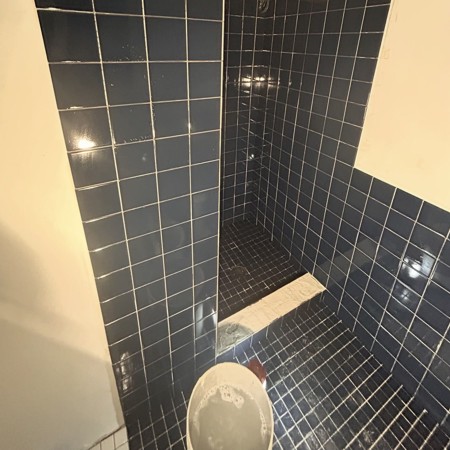 Bathroom shower tile installation with curb and floor tile installed