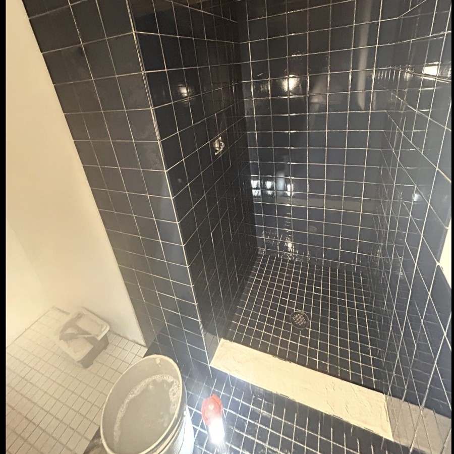 Dark square wall and floor tile installed in bathroom shower