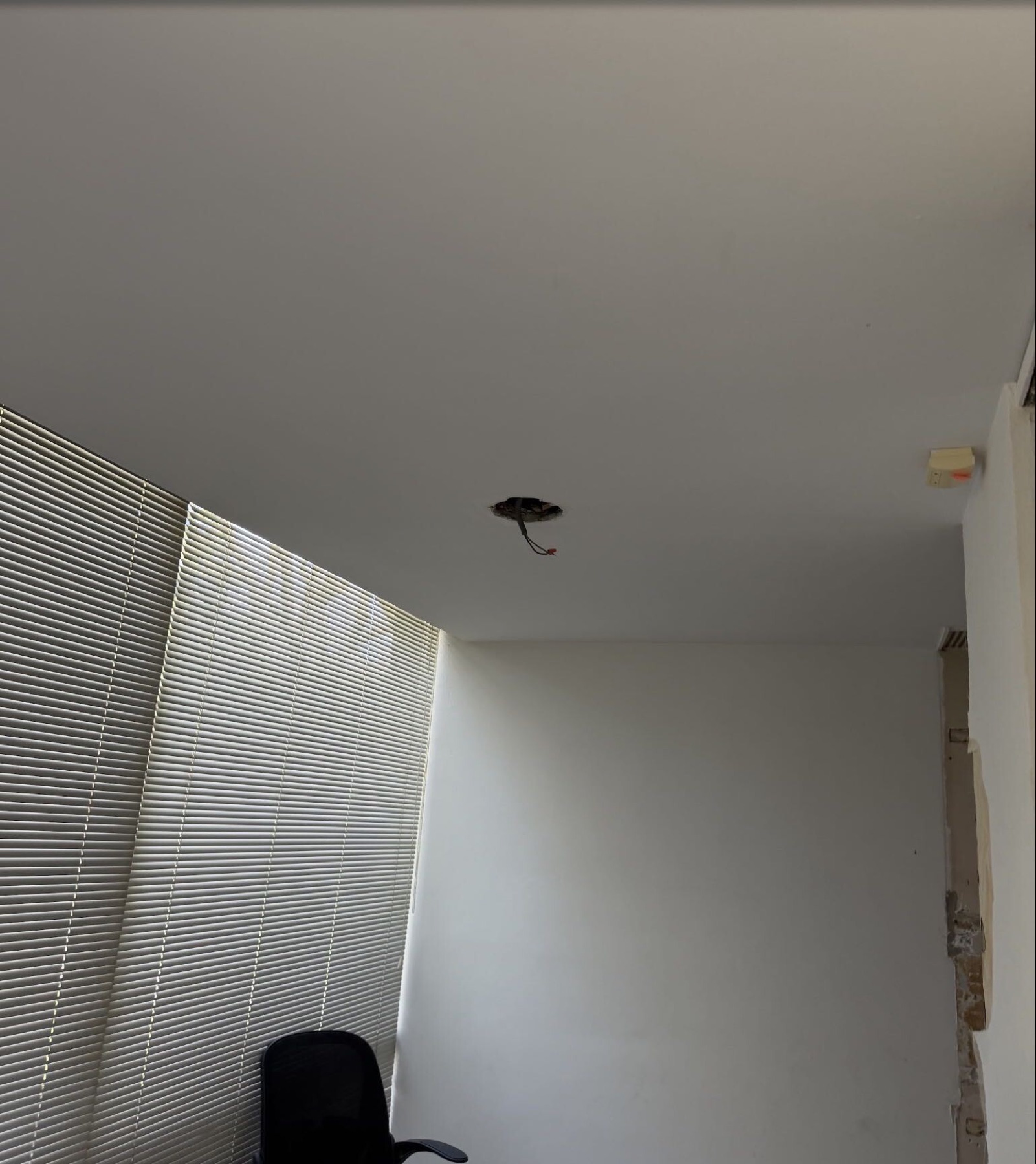 Interior room with blinds and ceiling opening